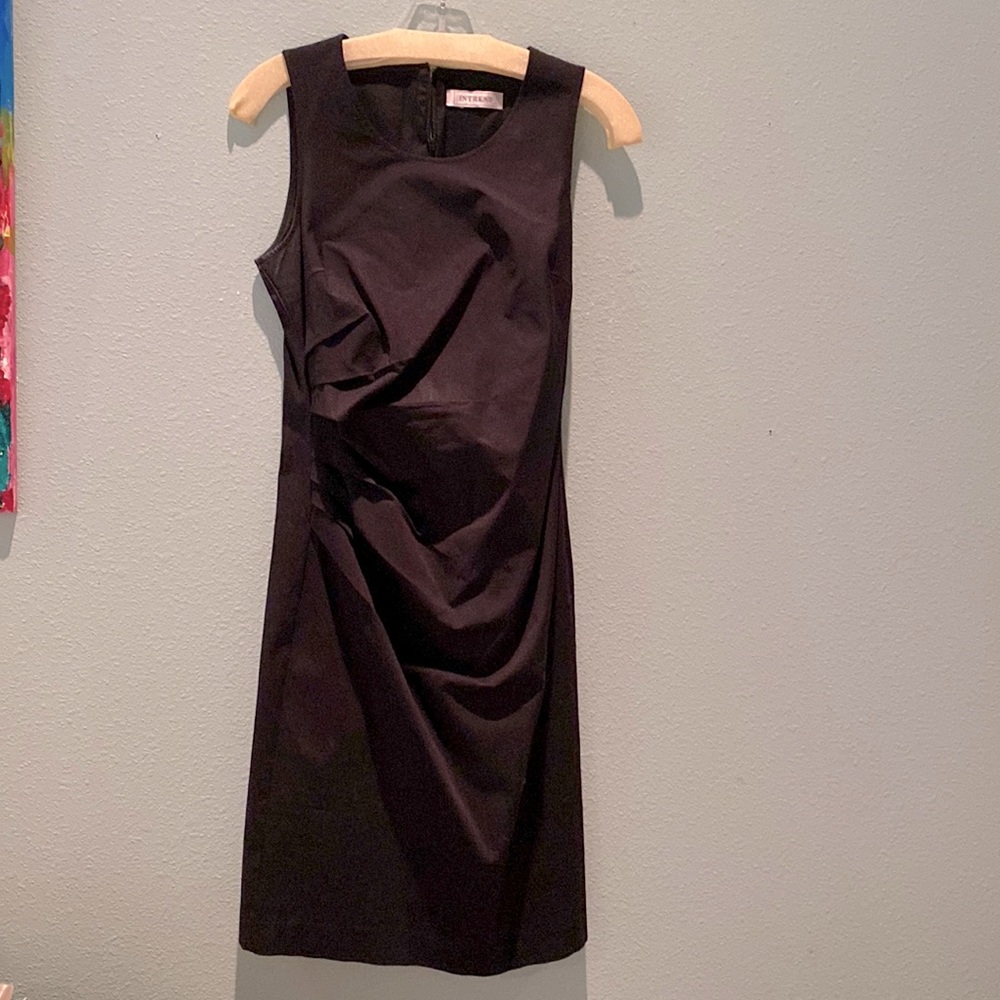 Sleeveless cotton black dress with side pleating.
